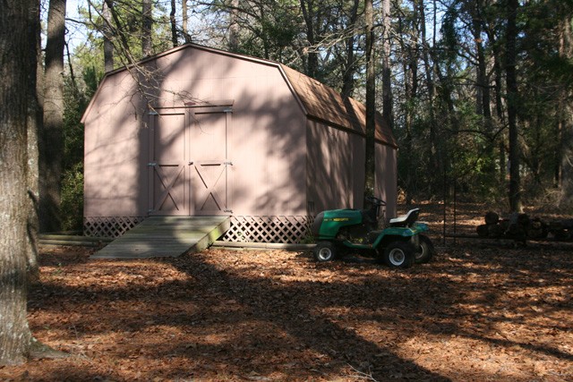 very large storage shed somewhat hidden in the woods.