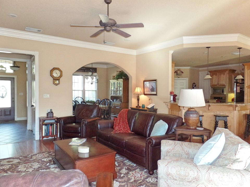 living with can lighting and crown molding open to kitchen and dining